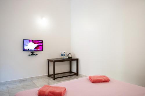 瓦加托Hill Top Nest的一间卧室配有一张床,墙上配有电视