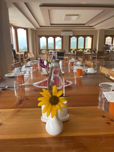帕罗Shomo Chuki Resort的一张长木桌,花瓶上放着黄花