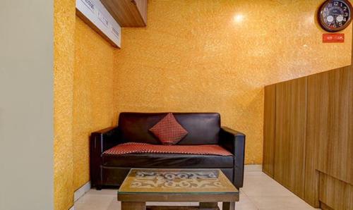 孟买FabExpress Prakash Inn的客厅配有真皮沙发和桌子