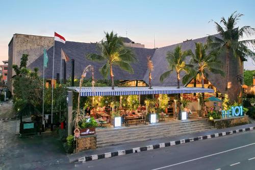 沙努尔THE 1O1 Bali Oasis Sanur的棕榈树建筑一侧的餐厅