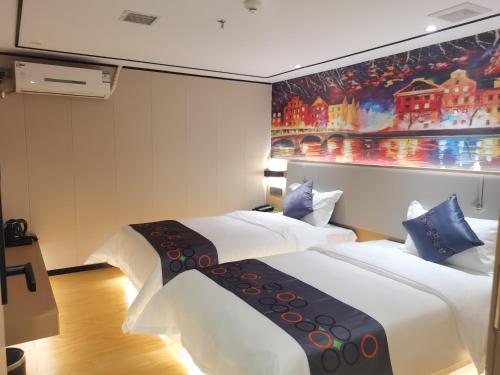 广州逸米米公寓(广州十三行一德路地铁站店)的酒店客房设有两张床,墙上挂有绘画作品