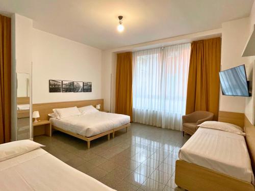 米兰Navigli Suites的一间酒店客房,设有两张床和电视