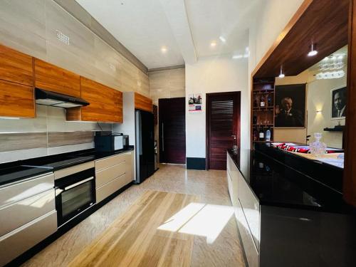 卢萨卡Pisano Luxury Apartments的厨房配有黑色家电和木制橱柜