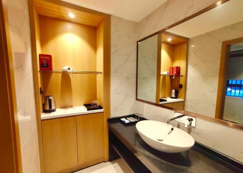 张家界Zhangjiajie ViVi Boutique Hotel的一间带水槽和镜子的浴室