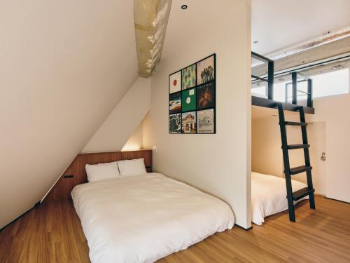 东京illi Com Shimokitazawa的一间卧室配有一张双层床和梯子