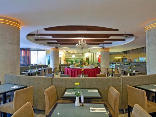 库塔库塔帕拉迪索酒店的一间带桌椅和吊灯的餐厅