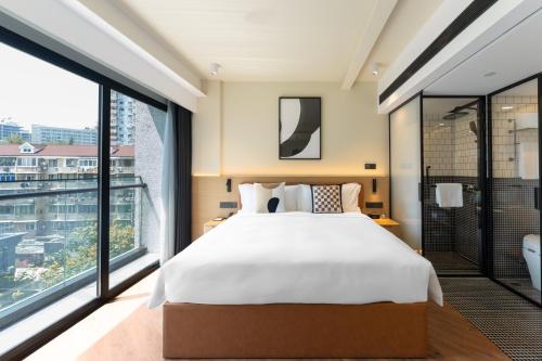 上海上海宓亚酒店(徐家汇交大店)的一间卧室设有一张大床和一个大窗户