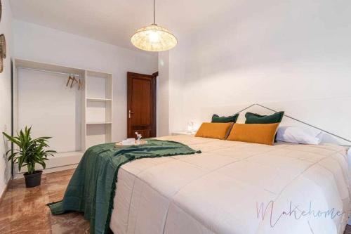 韦尔瓦A estrenar pleno centro parking的一间卧室配有一张带绿色和黄色枕头的大床