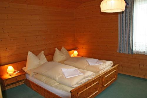 扎奥岑湖Liftgasthof Appartements的木制客房的一张床位,配有两个枕头