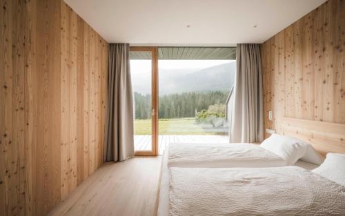 新黎凡特Karerhof的一间卧室设有两张床和大窗户