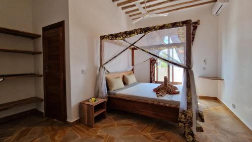 帕杰Bantu Home的一间卧室设有天蓬床和窗户。