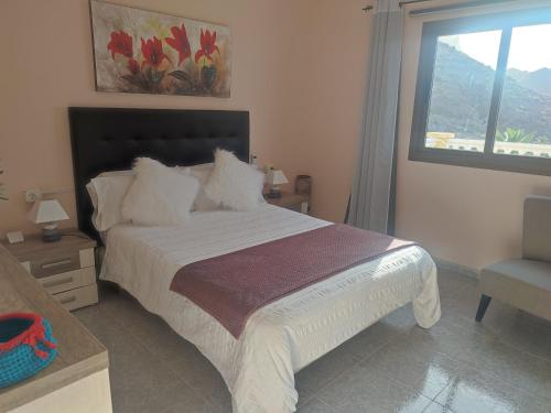 AlojeraCasa Rural La Vega的一间卧室配有一张带窗户和椅子的床