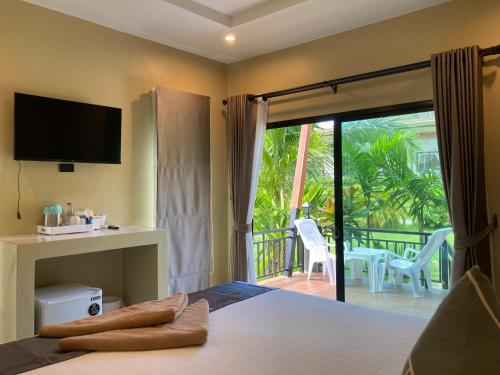 高兰Serene Lanta Resort的一间卧室设有一张带电视的床和一个阳台。