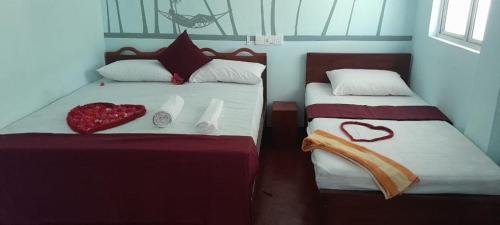 亭可马里DA GREA NATURAL BEACH HOTEL的一间卧室配有两张心形床。