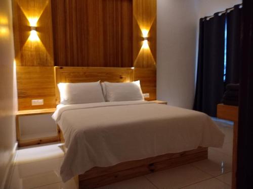 珍南海滩FUNDUQ AL BUSYRA的一间卧室配有一张大床和木制床头板