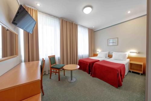 塔林Rixwell Viru Square Hotel的酒店客房设有两张床和一台平面电视。