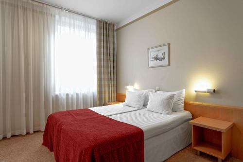 塔林Rixwell Viru Square Hotel的一间卧室配有一张带红色毯子的床和窗户。