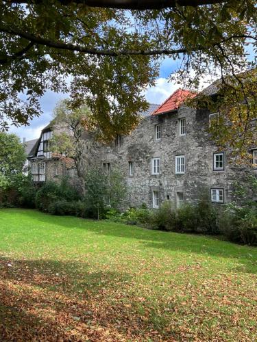 帕德博恩Premium Apartment an der Stadtmauer im OG的一座红色屋顶的古老石头建筑