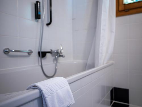 格里门茨Hôtel Cristal - Swiss Riders Lodge Grimentz的白色的浴室设有毛巾和淋浴