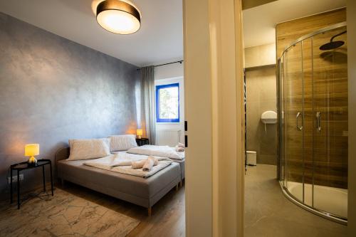 旧柳博夫尼亚Športové a relaxačné centrum - ŠRC的一间卧室设有一张床和一个步入式淋浴间。