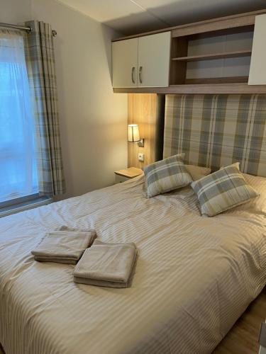 克诺克－海斯特Luxury seaside cottage 29的一张大床,上面有两条毛巾