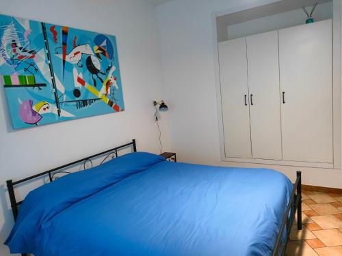 拉奎拉Appartamento Fontesecco的卧室配有一张床,墙上挂有绘画作品