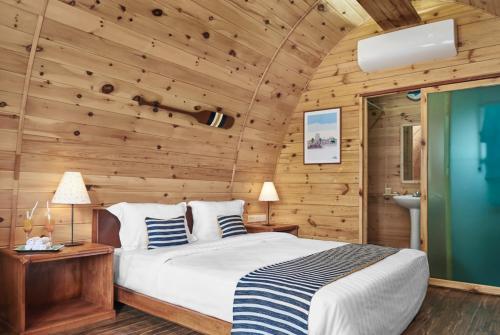 西哈努克Pod Village by Independence Hotels的一间卧室设有一张床和木墙