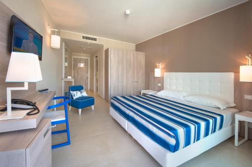 伊索拉阿尔巴勒拉Isola di Albarella Hotel Capo Nord的配有一张床和一张书桌的酒店客房