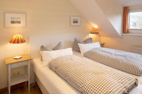 朗格奥FREESENHOFF Freesenhoff -OFDAK-的一间卧室设有两张床和一张带台灯的桌子。