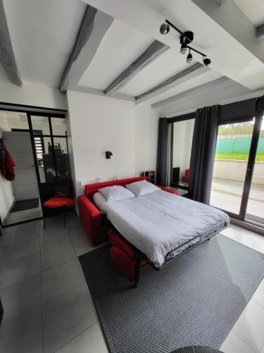 阿姆博斯Joli appartement avec vue sur la Loire的一间卧室配有一张床和一张红色的沙发