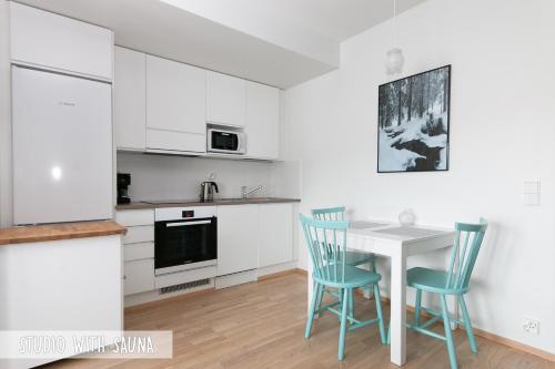 罗瓦涅米皮里科公寓的厨房配有白色橱柜和桌椅