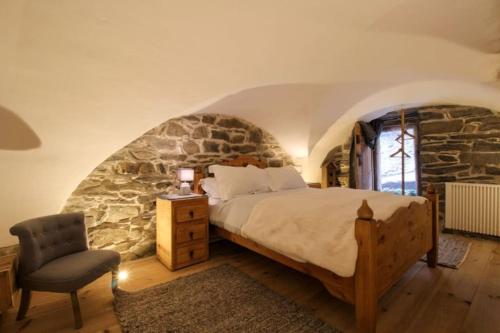 Saint-MarcelCharmante maison de hameau traditionnel montagnard的一间卧室设有一张床和石墙