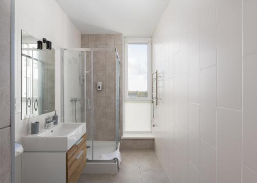 基辅Nyvky Residence的带淋浴和盥洗盆的白色浴室