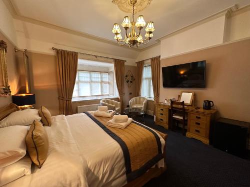 切斯特切斯特苑酒店的一间卧室配有一张床、一张书桌和一台电视