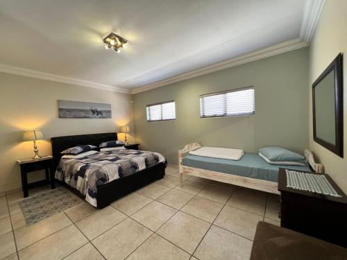 鲸湾港Nomland的一间卧室配有一张床和长凳