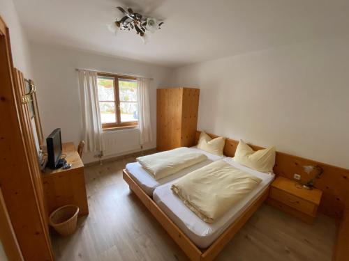 塞费尔德附近赖特梅勒霍夫酒店的一间卧室配有一张带白色床单的床和一扇窗户。