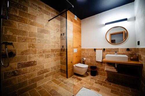 Cîmpu lui Neag卡乐布迪旅游酒店的一间带卫生间、水槽和镜子的浴室