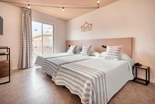 罗列特海岸tent Lloret de Mar的卧室设有2张床和白色的墙壁。
