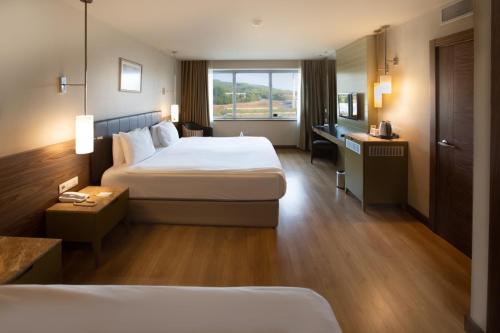 恰纳卡莱Kolin Hotel Spa & Convention Center的酒店客房设有两张床和窗户。