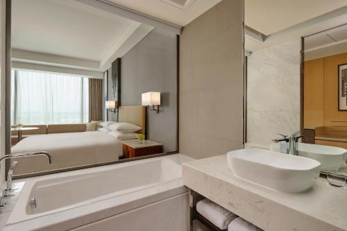 名古屋Batam Marriott Hotel Harbour Bay的一间带床、浴缸和水槽的浴室