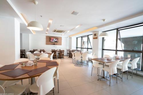 伊塔博拉伊伊塔博拉伊长廊尊贵公寓式酒店的用餐室配有桌子和白色椅子