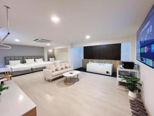 南邦The Space Hotel Lampang的客厅配有白色家具和电视