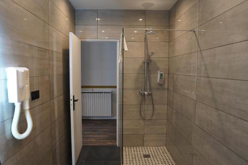 巴黎蒙庞西耶酒店的带淋浴的浴室和墙上的电话