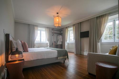 蓬塔德尔加达Casa Portuguesa - Charming House的一间卧室配有一张床、一张沙发和窗户。