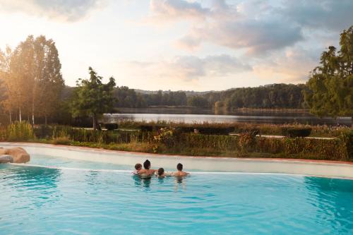 沙穆伊Center Parcs Le Lac d’Ailette的三人在带湖泊的游泳池里
