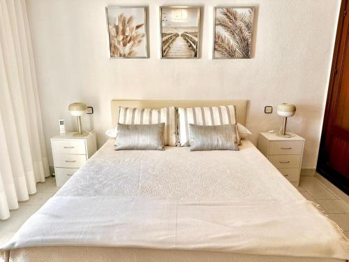 福恩吉罗拉Fuengirola Casa Centro Mar y Sol的一间卧室配有一张带两盏灯的大型白色床。