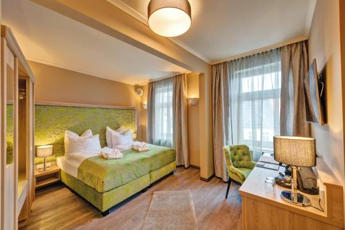 吕本瑙SPREE Hotel in der Altstadt的配有一张床和一把椅子的酒店客房