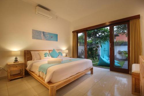 沙努尔Villa Lotus Flower Sanur的一间卧室设有一张床和一个大窗户