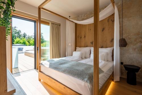 希欧福克REED Luxury Hotel by Balaton的一间卧室设有一张天蓬床和一个阳台