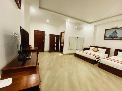 绥和市Jen Hotel的酒店客房设有两张床和电视。